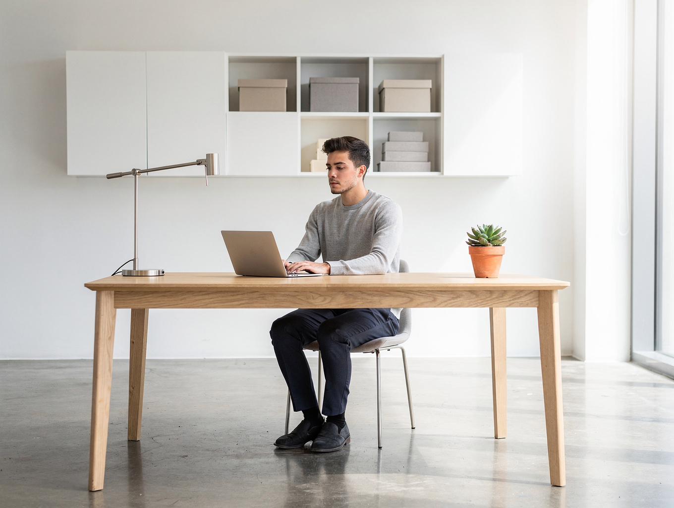 Editor working at a tidy wooden desk with a relaxed dog on a cushion